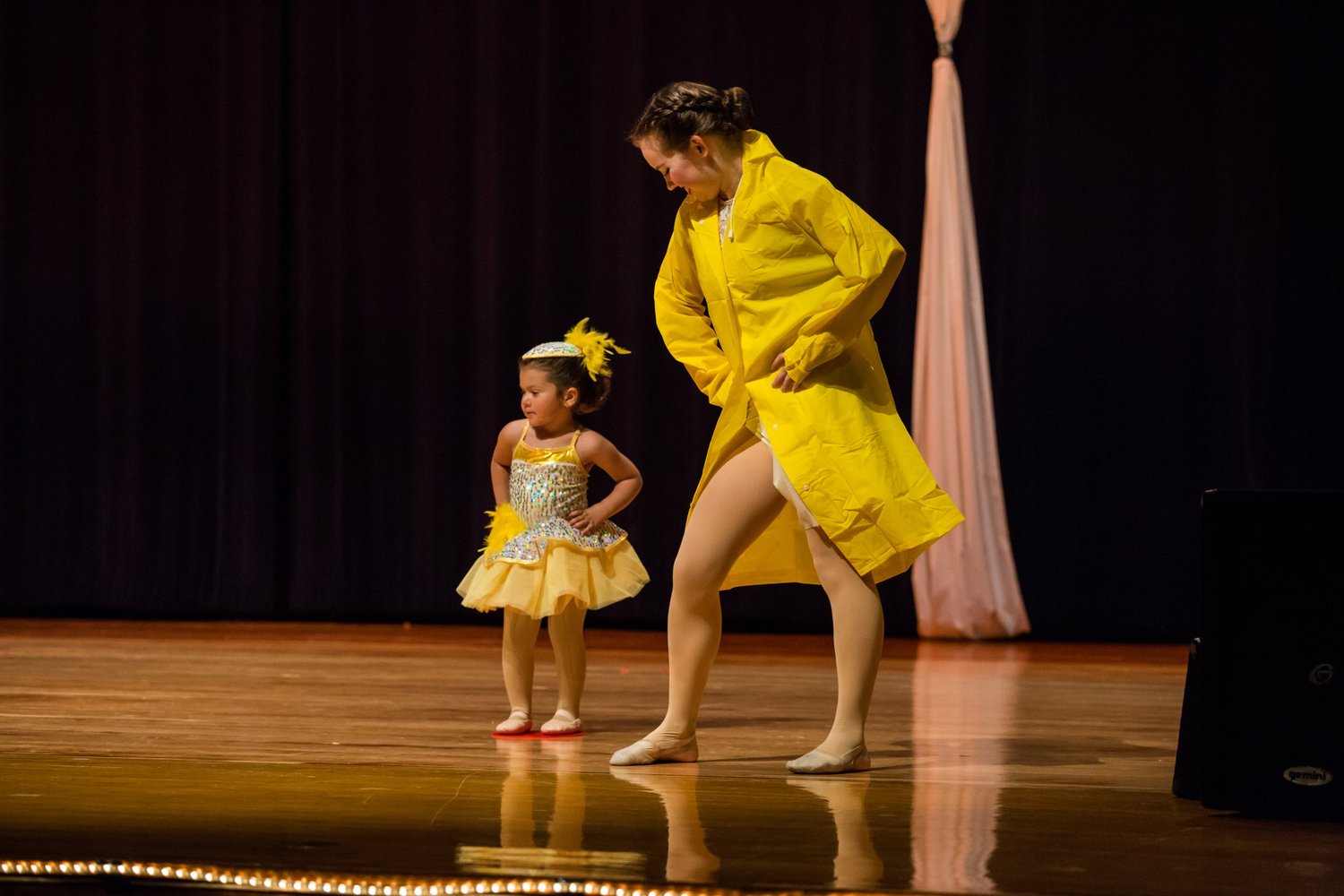 A Rising Stars teacher dancing with a young student on stage